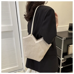 Détail du cabas tissé beige avec garniture en cuir crème et découpe en forme de V