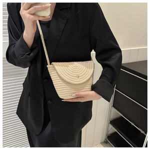 Détail du sac carré en paille tressée crème avec texture semi-circulaire et bandoulière