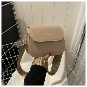 Dettaglio borsa beige con patta a trama coccodrillo e tracolla in tessuto jacquard