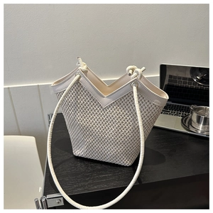 Détail du sac fourre-tout tissé crème avec coupe en V et fines bandoulières tubulaires