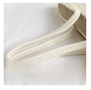 Detailed macro view of the thick woven cotton rope handle on a white beach tote bag