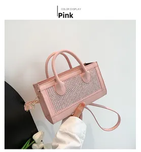 Detailed view of a pink rivet crossbody bag with sparkling silver studs and top handles