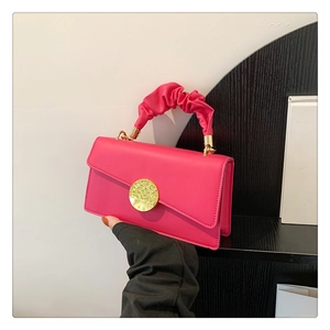 Detail of rose pink handbag with golden buckle and stylish ruched fabric handle