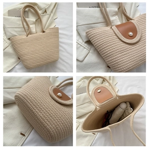 Détail du sac cabas tressé avec rabat en cuir marron et ornement perle décorative