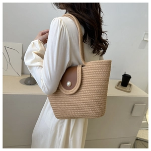 Détail du sac fourre-tout en paille tissée avec rabat en cuir et perle élégante