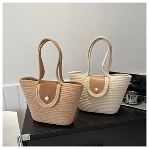 Détail d'un sac cabas tissé avec rabat en cuir et fermoir élégant en perles