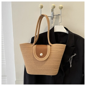 Détail du sac cabas tissé avec rabat en similicuir marron et bouton perle décoratif