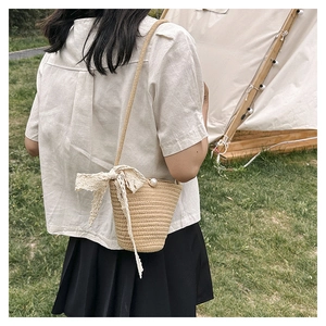 Stroh-Eimertasche mit Perlenverschluss und Spitzenband-Detail in einer Außenaufnahme
