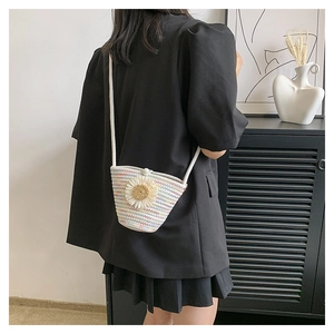 Vue détaillée d'un sac à bandoulière tissé aux tons macarons avec une grande marguerite blanche