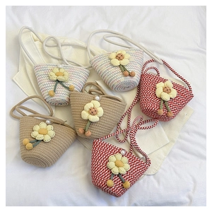 Detail of hand-woven floral bucket bags with colorful patterns and pearl sun flowers