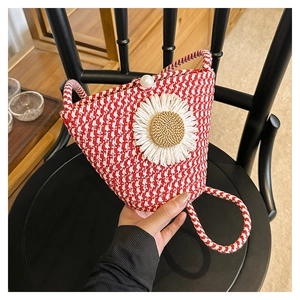 Détail du sac tissé rouge et blanc avec marguerite, fermoir perle et bandoulière tressée