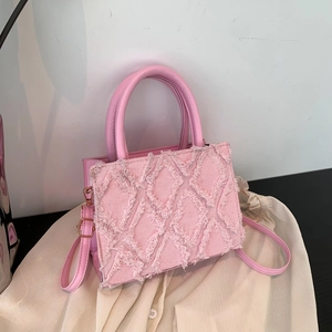 Pink crossbody square bag with frayed fabric texture and golden hardware accents