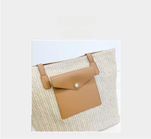 Detail of straw woven tote bag featuring brown leather pocket and elegant pearl closure