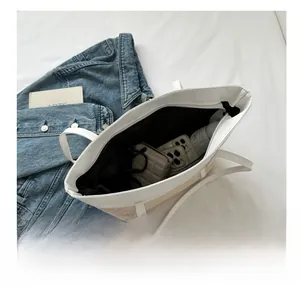 Internal storage view of straw tote bag showing spacious capacity for phone and wallet