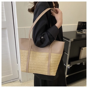Detail of contrast stitching and V-pattern straw weave on large beige tote bag