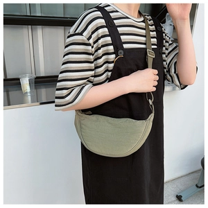 Olive green nylon crescent bag showing large capacity and adjustable strap on a model
