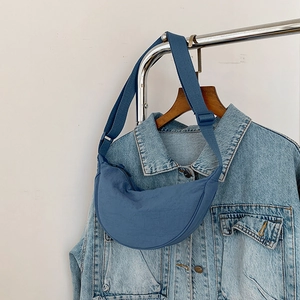 Detail of blue crescent bag with pleated nylon fabric and adjustable wide strap