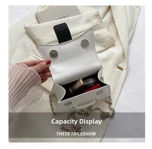 Mini white leather crossbody bag interior showing storage for lipstick and cosmetics