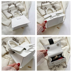 Detail view of white mini trapezoid handbag showing silver chain and interior space