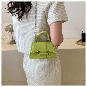 Lime green mini square bag with silver chain strap shown worn with a chic tweed outfit