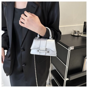 Silver metallic mini bag with chain strap styled with black satin dress and blazer
