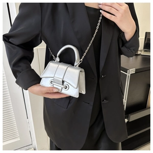 Close-up of metallic silver mini hourglass bag with chain strap and ring clasp