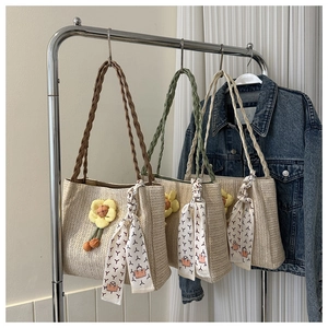 Detail of woven straw tote bags with floral accents and decorative printed silk scarves