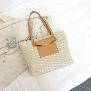 Large straw bucket tote bag with brown leather straps and pearl button detail
