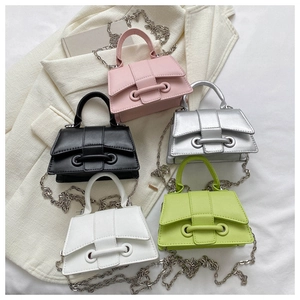 Flat lay of five mini crossbody bags in assorted colors with silver chain straps