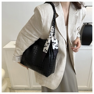 Detail of black tote bag with houndstooth texture and stylish silk scarf handle wrap