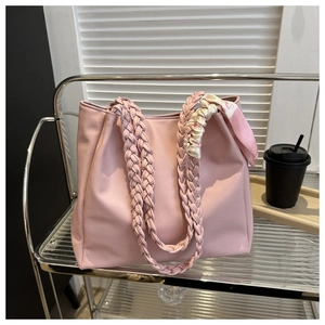 Pink tote bag detail with thick braided handles and elegant silk scarf accessory