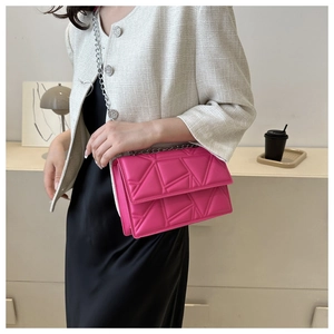 Borsa a tracolla trapuntata color magenta con catena d'argento indossata da modella