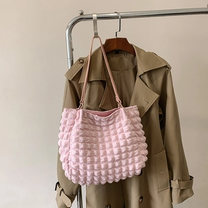 Detail of pink bubble texture tote bag hanging on a minimalist stainless steel rack