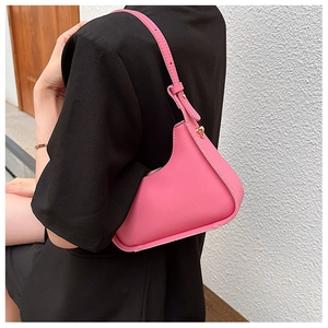Bandoulière réglable et détails dorés sur un sac porté épaule géométrique rose vif