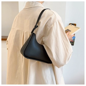 Vue arrière d'un mannequin portant un sac hobo demi-lune en cuir noir mat à l'épaule
