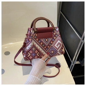 Detail of bohemian woven handbag featuring geometric patterns and round wooden handles