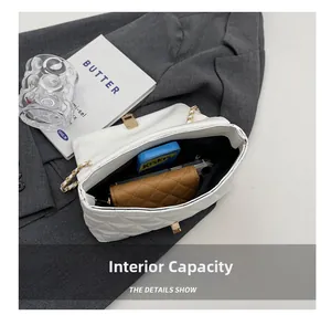 Detail of white quilted crossbody bag showing internal capacity with phone and wallet
