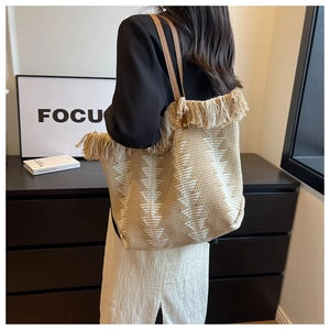 Detail of bohemian woven tote bag with fringe edge and geometric triangle patterns