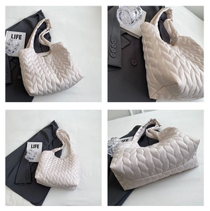 Detail view of cream quilted puffer tote bag with woven texture and integrated handle