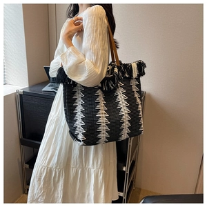 Detail of woven tote bag with fringe edge and black and white geometric tree pattern