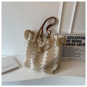 Detail of woven tote bag with fringe edge and geometric patterns in bohemian style