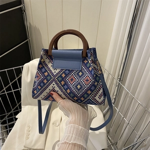 Bohemian woven handbag with geometric patterns, wooden handles and a blue leather strap