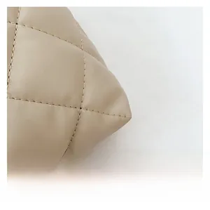 Detail of light khaki quilted leather tote showing precise stitching and soft texture
