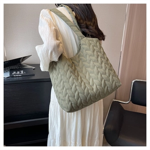 Sage green quilted tote bag shown in a professional setting for daily commute usage