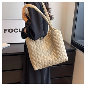 Close-up of beige quilted tote bag showing unique 3D leaf-shaped woven texture detail