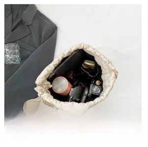 Internal storage view of quilted cream bucket bag showing high capacity for tablets and daily items