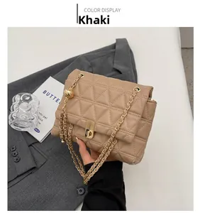 Detail of khaki quilted shoulder bag with golden chain strap and metal ball decor