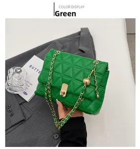 Detail of green quilted crossbody bag featuring a golden ball chain and twist lock