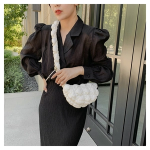 Close-up of white quilted bubble fabric crossbody bag showing texture and soft material