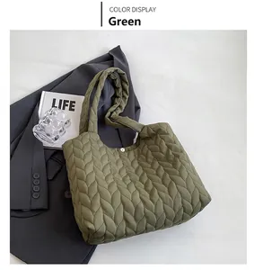 Detail of army green quilted tote bag with texture and magnetic snap closure on fabric